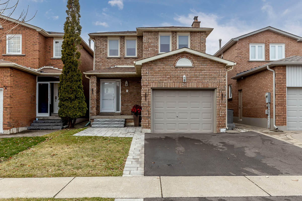 Lifestyle Construction Two-story brick house with a garage, small front lawn, and a tree on the left, showcasing Home Renovation Vaughan expertise in every detail. Home Renovation In The GTA